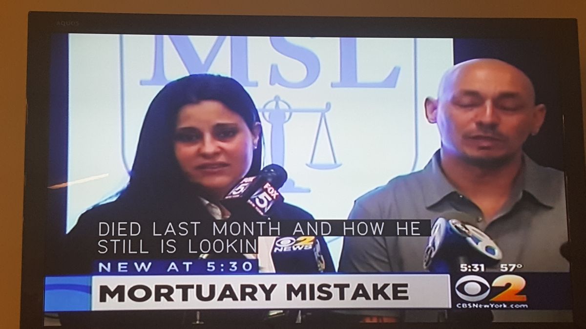 CBS2 New York 5:30 news segment titled Mortuary Mistake, showing the family at a press conference in front of the firm's logo